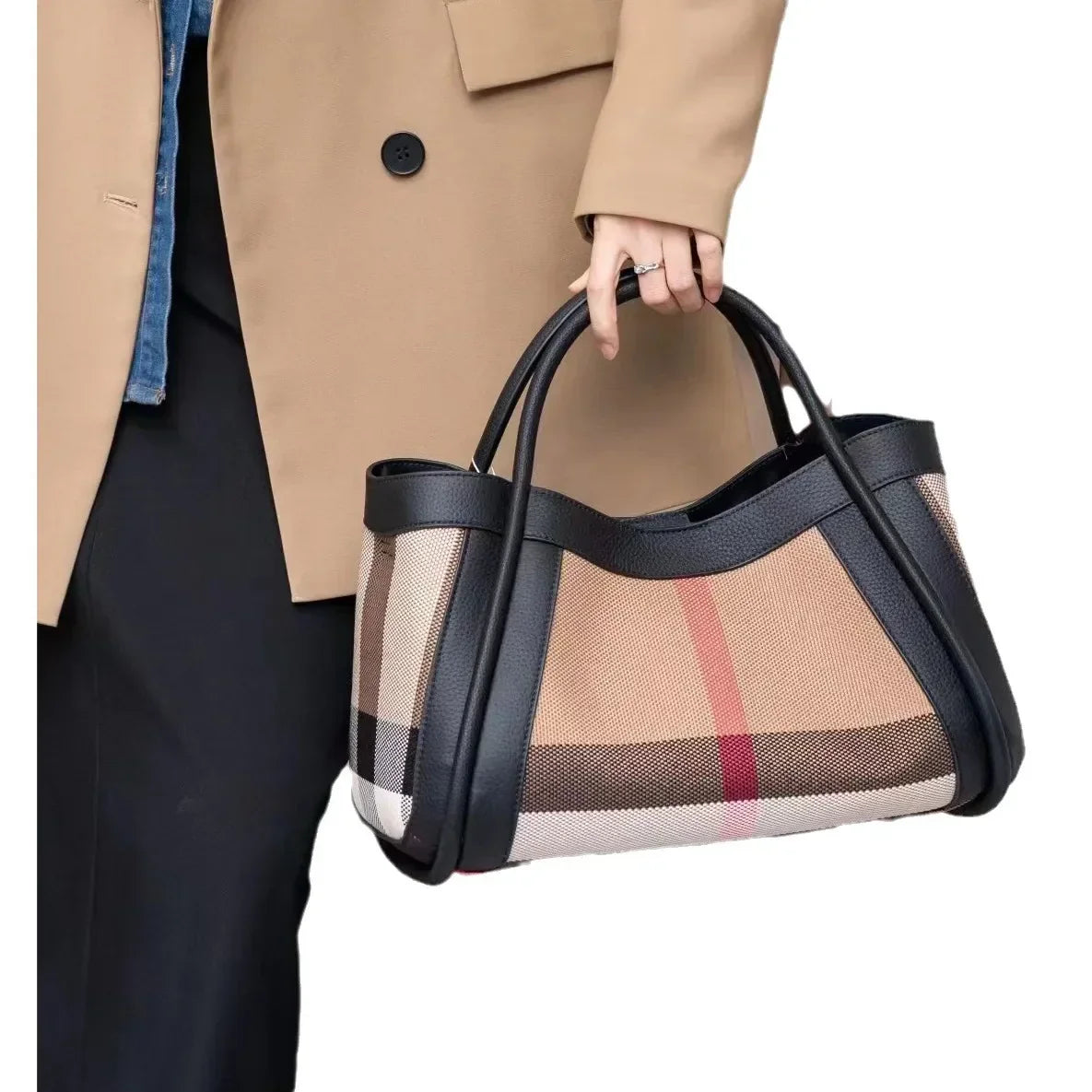 Borsa a mano elegante con motivo a quadri, dettagli in pelle nera, indossata da una persona con cappotto beige. Accessorio moda di tendenza.