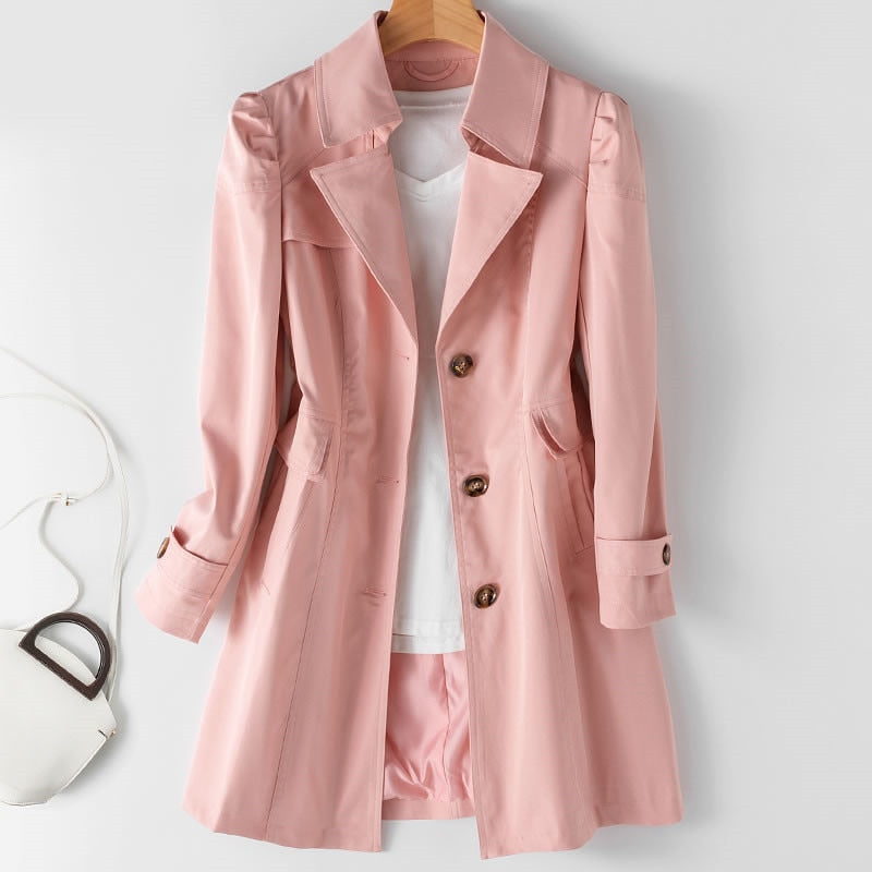 Cappotto rosa da donna elegante, con bottoni marroni, appeso su gruccia, abbinato a maglietta bianca. Moda femminile, abbigliamento autunnale.