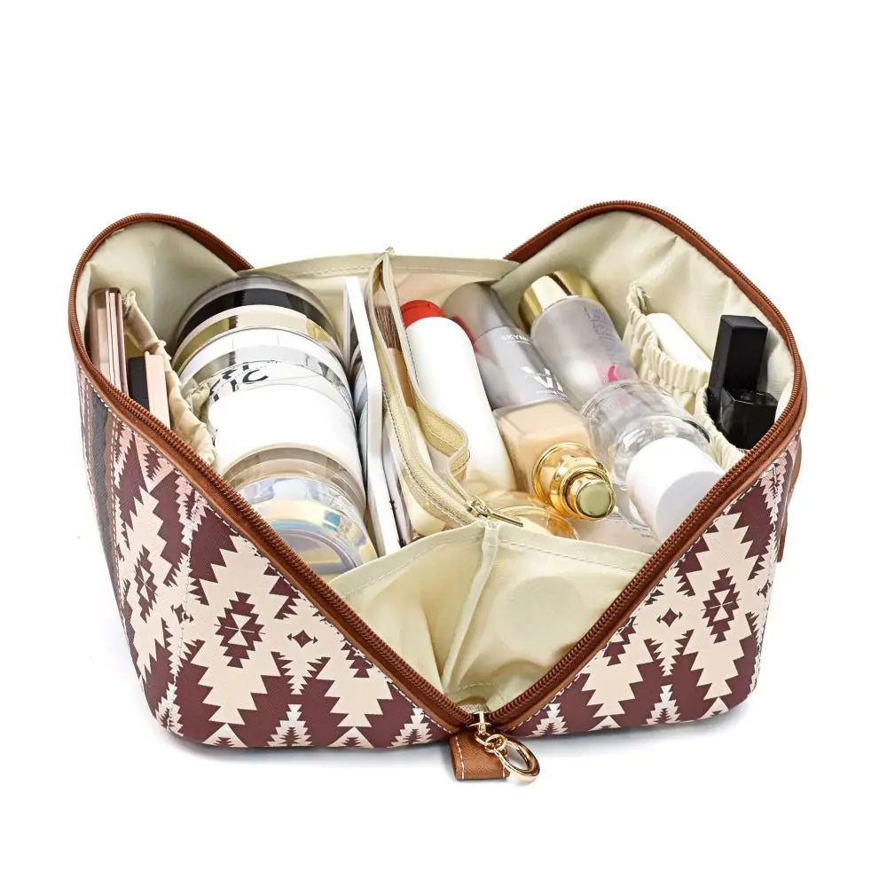 Borsa cosmetica aperta con motivo geometrico marrone, contenente vari prodotti di bellezza e trucco. Organizer da viaggio per cosmetici.