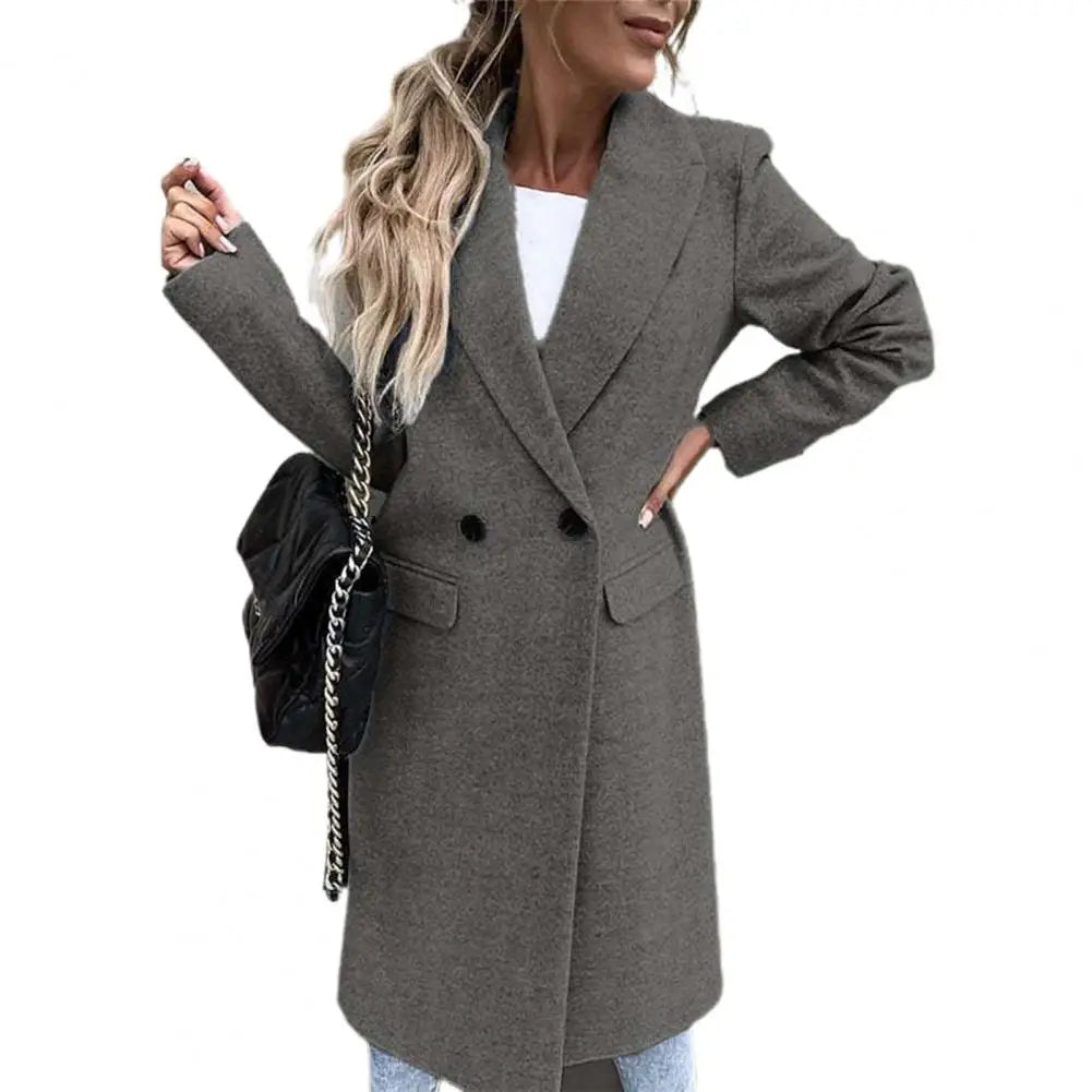 Cappotto donna grigio elegante, doppio petto, con tasche, indossato con borsa nera a tracolla. Ideale per moda autunno-inverno.