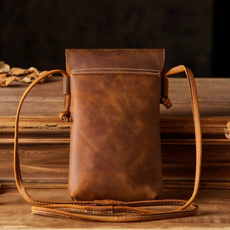 Borsa a tracolla in pelle marrone vintage, design elegante e compatto, ideale per uomo e donna, perfetta per smartphone e accessori essenziali.