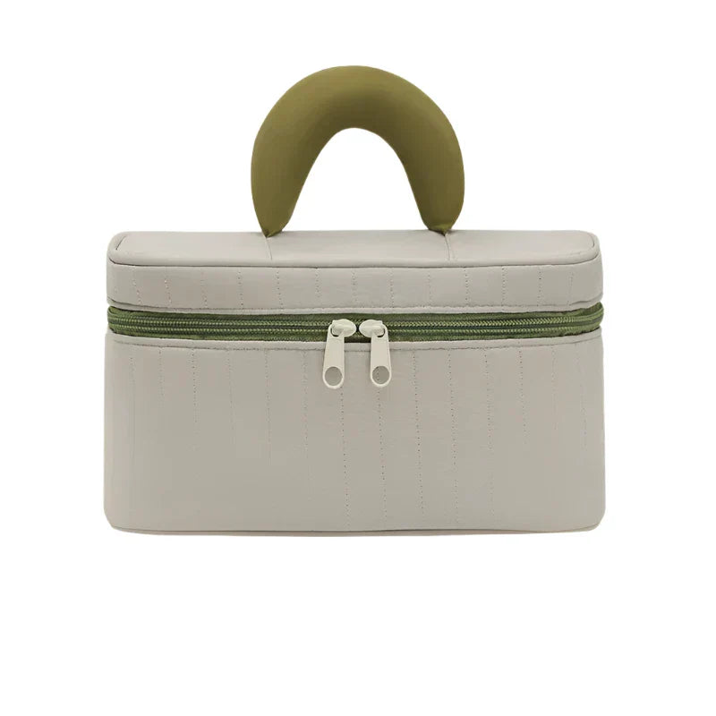 Borsa cosmetica beige con manico verde, chiusura a doppia zip, design elegante e compatto, ideale per viaggi e organizzazione trucco.