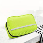 Borsa da toilette verde impermeabile su lavandino bianco, design compatto con cerniera, ideale per viaggi e organizzazione bagno.