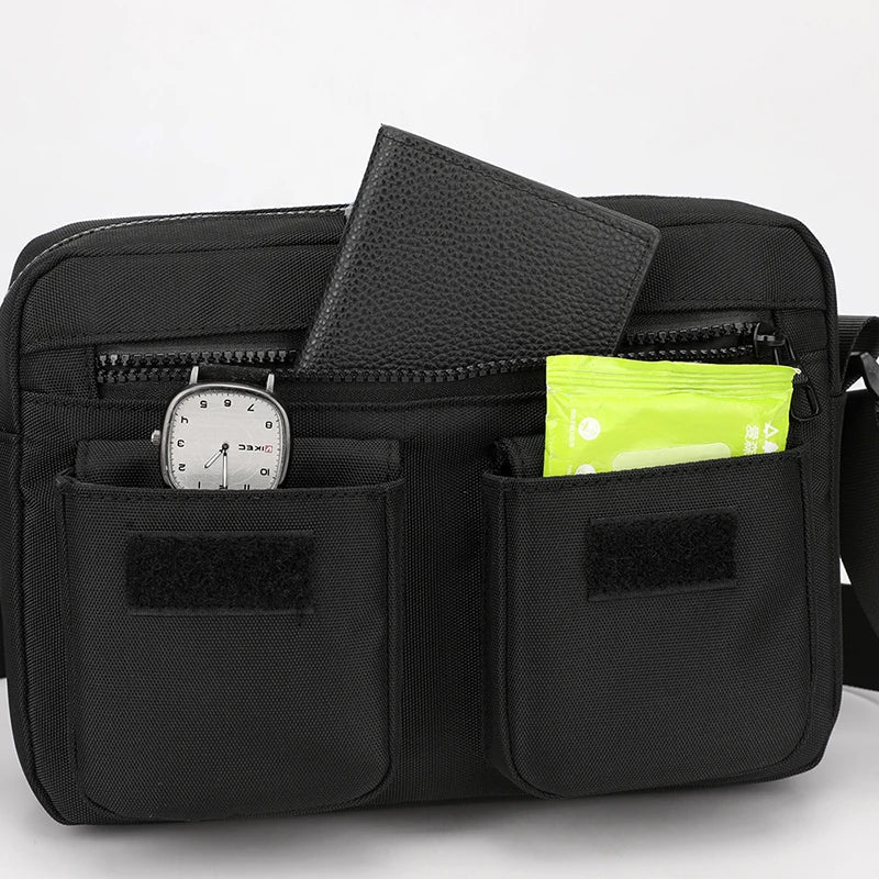 Borsa a tracolla nera con tasche multiple, orologio, portafoglio e pacchetto verde. Accessorio moda uomo, pratico e versatile.
