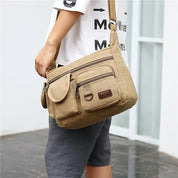 Borsa a tracolla in tela beige, uomo, tasche multiple, stile casual, ideale per viaggi e uso quotidiano. Accessorio moda pratico e resistente.