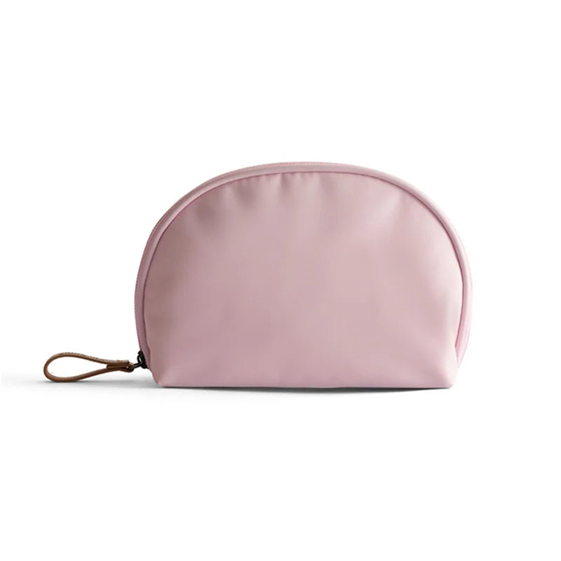 Astuccio cosmetico rosa chiaro in tessuto impermeabile con cerniera e laccio in pelle. Ideale per trucco e accessori da viaggio.