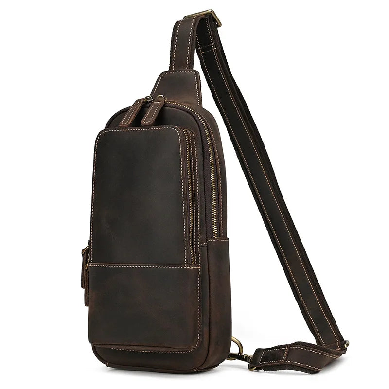 Zaino monospalla in pelle marrone scuro, design elegante e compatto, con cerniere dorate e tracolla regolabile. Ideale per uomo e donna.