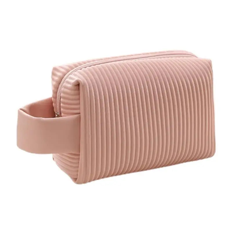 Astuccio da toilette rosa in silicone con design a coste, chiusura a zip e manico laterale. Ideale per viaggi, resistente e impermeabile.
