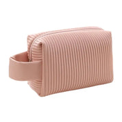 Astuccio da toilette rosa in silicone con design a coste, chiusura a zip e manico laterale. Ideale per viaggi, resistente e impermeabile.