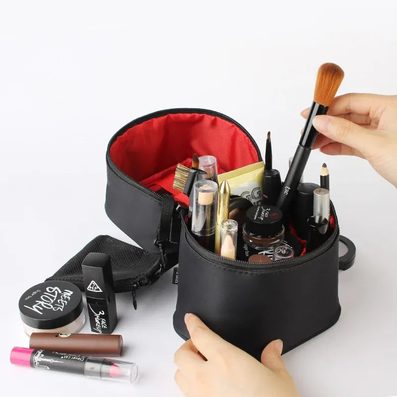 Borsa trucco nera aperta con pennelli, rossetti e cosmetici vari su sfondo bianco. Accessori make-up essenziali per bellezza e cura personale.