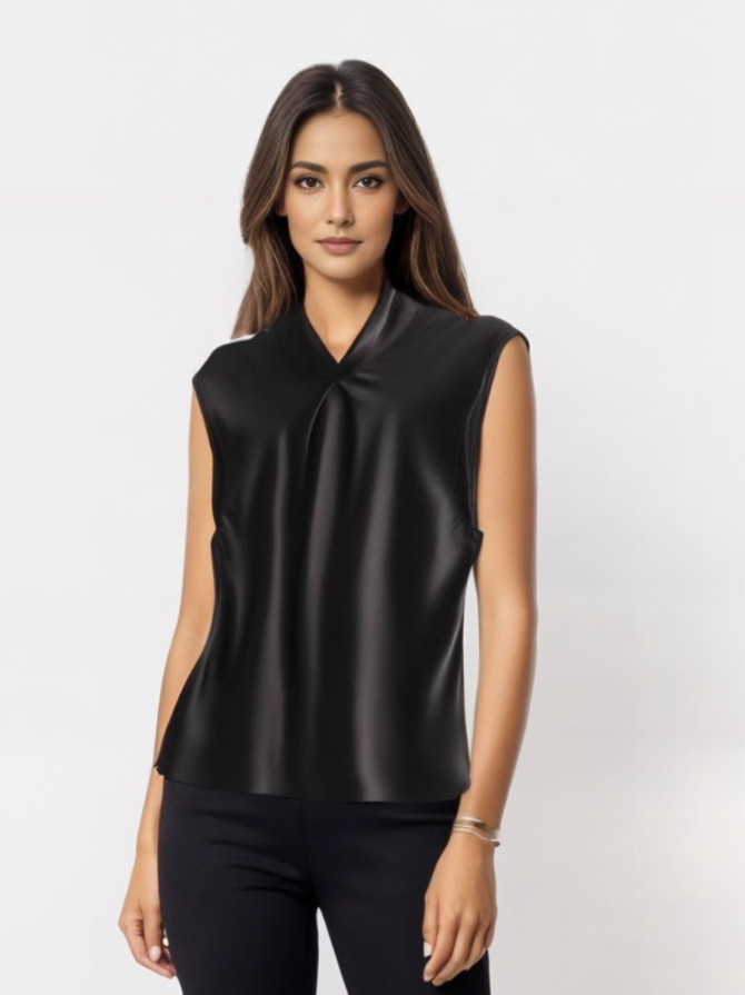 Donna con top nero senza maniche, elegante e moderno, su sfondo bianco. Moda femminile, abbigliamento casual chic, stile minimalista.