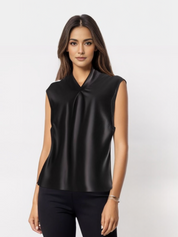 Donna con top nero senza maniche in raso, design elegante e moderno, sfondo bianco. Abbigliamento femminile alla moda, stile sofisticato.