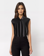 Donna con top nero senza maniche in raso, elegante e moderno, su sfondo bianco. Moda femminile, abbigliamento chic, stile sofisticato.