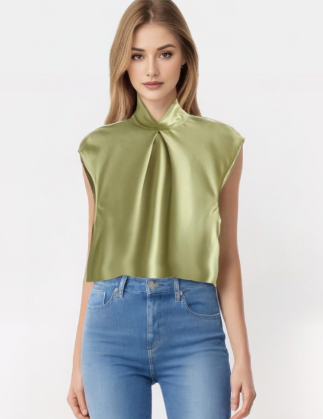 Blusa satinata verde chiaro con colletto annodato, senza maniche, indossata da modella. Elegante top in raso, perfetto per look casual e formali.