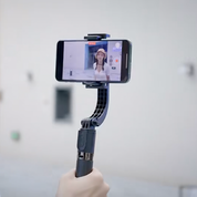 Smartphone su stabilizzatore gimbal, ripresa video di una donna. Accessorio per video stabili, ideale per vlogging e creazione contenuti.