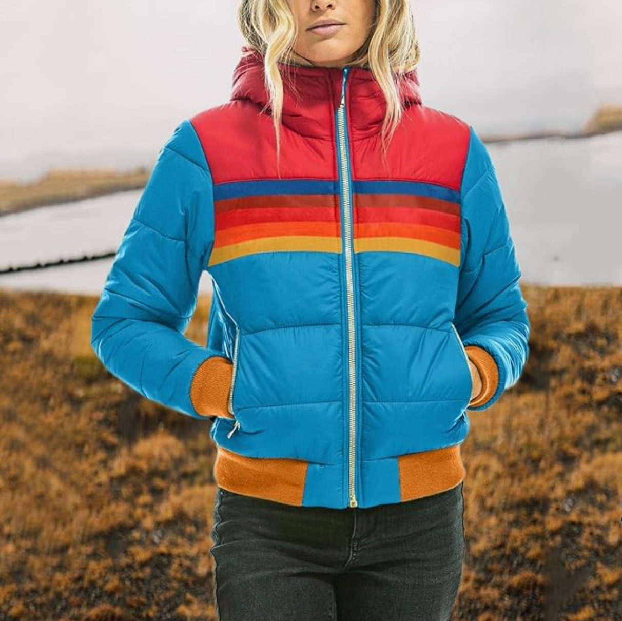 Giacca invernale colorata da donna con cappuccio, design a righe rosse e arancioni, perfetta per escursioni e attività all'aperto.