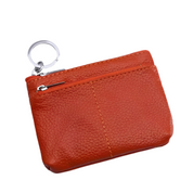 Portachiavi in pelle arancione con cerniera, design compatto, ideale per monete e chiavi. Accessorio elegante e pratico per l'uso quotidiano.