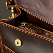 Borsa a tracolla in pelle marrone con cuciture a contrasto, chiusura magnetica e zip interna. Accessorio elegante e funzionale per uomo o donna.
