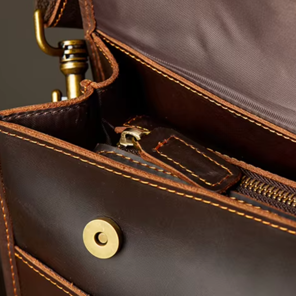Borsa a tracolla in pelle marrone con cuciture a contrasto, chiusura magnetica e zip interna. Accessorio elegante e funzionale per uomo o donna.