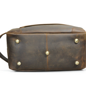 Borsa a tracolla in pelle marrone vintage, base con piedini metallici dorati, design elegante e resistente, ideale per uomo e donna.