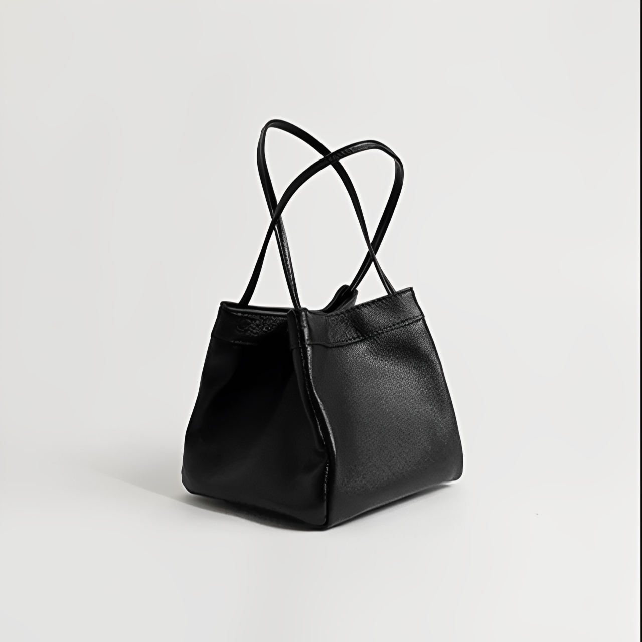 Borsa a mano in pelle nera elegante con doppio manico, design minimalista, perfetta per moda donna, accessorio di lusso, stile contemporaneo.
