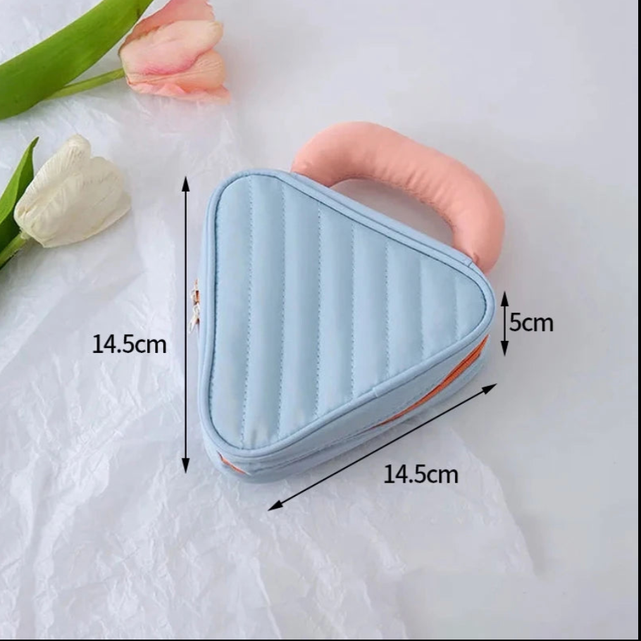 Borsa a forma di triangolo azzurro con manico rosa, dimensioni 14,5x14,5x5 cm, su sfondo bianco con fiori. Accessorio moda elegante e compatto.
