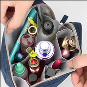 Borsa cosmetica aperta con vari flaconi di profumi, rossetti e accessori trucco. Organizer da viaggio, beauty case compatto, accessori make-up.