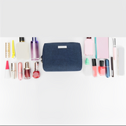 Astuccio cosmetico blu con vari prodotti di bellezza: rossetti, profumi, smalti e creme. Organizzatore trucco da viaggio, accessori moda donna.
