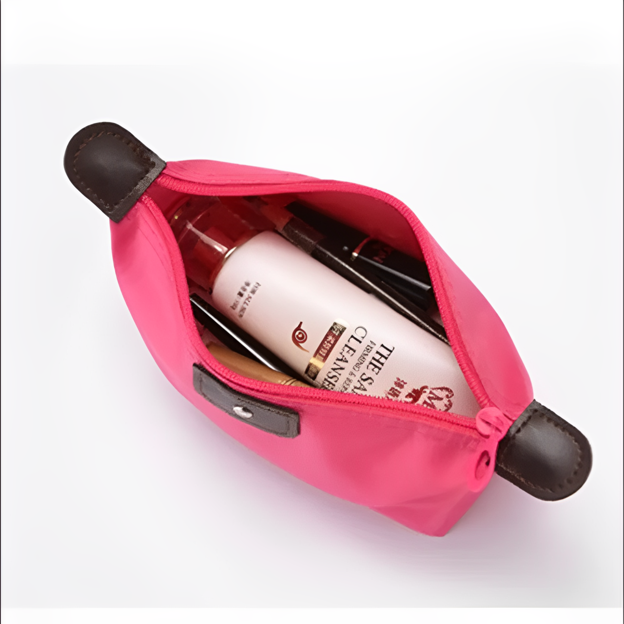 Astuccio cosmetico rosa aperto con prodotti di bellezza, tra cui detergente viso e pennelli trucco. Accessorio moda donna, pratico e compatto.