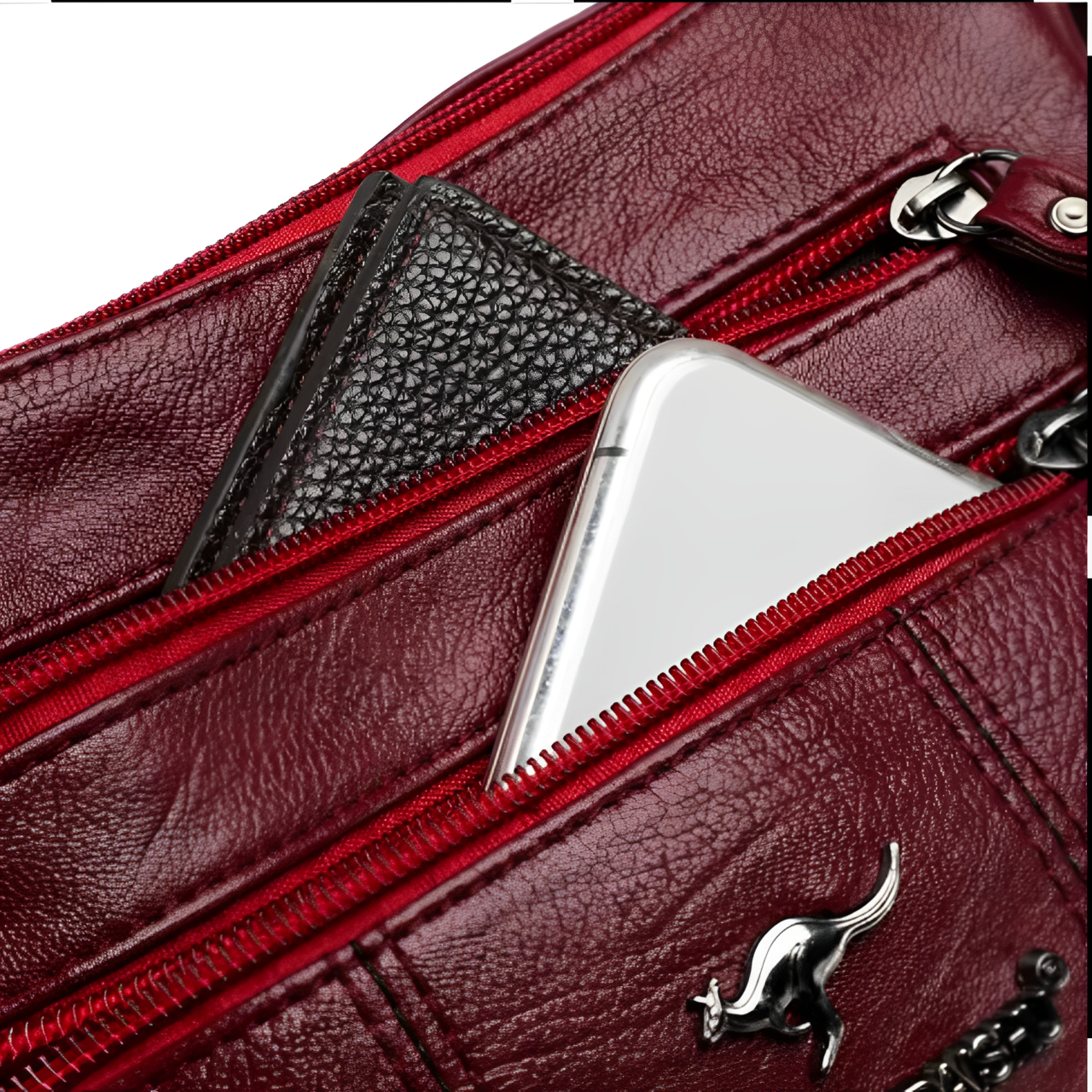 Borsa in pelle rossa con cerniera, portafoglio nero e smartphone visibili. Accessori moda eleganti, alta qualità, stile moderno.