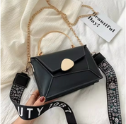 Borsa a tracolla nera elegante con manico dorato, catena e cinturino decorato. Design moderno, perfetta per moda donna. Accessorio chic e versatile.