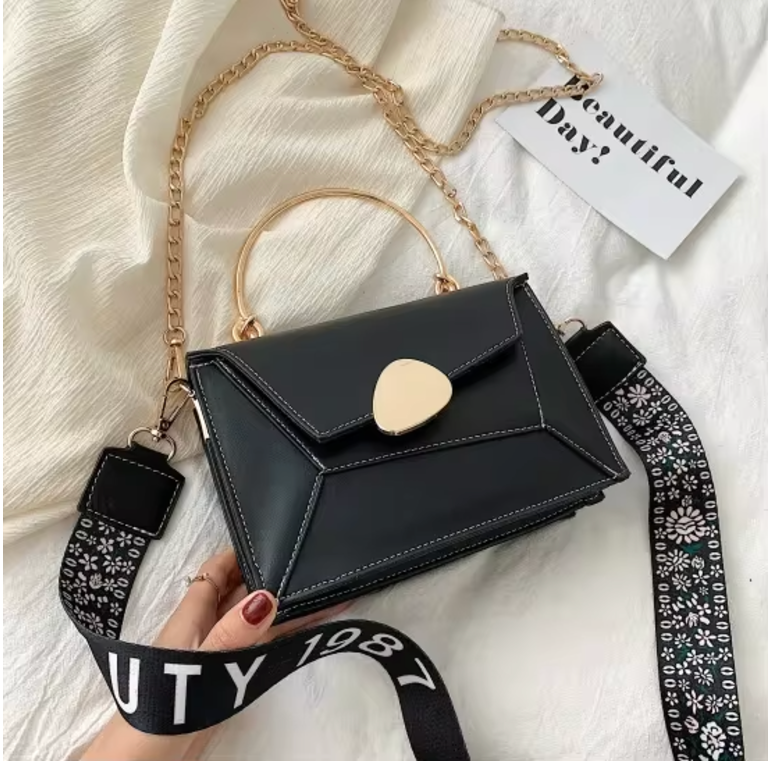 Borsa a tracolla nera elegante con manico dorato, catena e cinturino decorato. Design moderno, perfetta per moda donna. Accessorio chic e versatile.