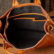Borsa in pelle marrone aperta, con tasche interne nere e cuciture a contrasto. Design elegante, ideale per moda donna e accessori di lusso.