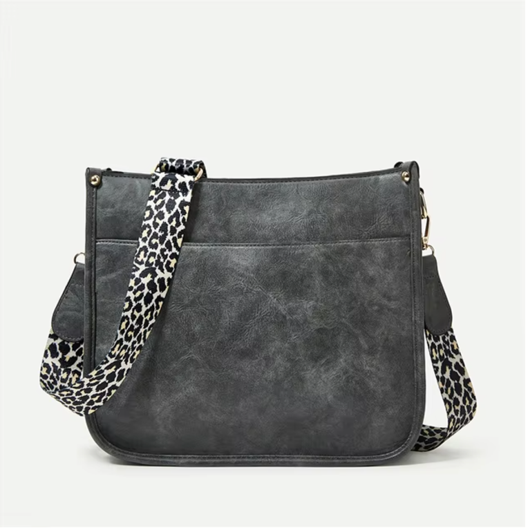 Borsa a tracolla in pelle nera con tracolla regolabile leopardata, design elegante e moderno, ideale per moda donna e accessori di tendenza.