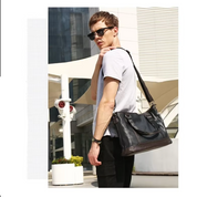 Uomo con occhiali da sole indossa borsa a tracolla in pelle nera, moda urbana, esterno moderno, abbigliamento casual, accessori maschili eleganti.