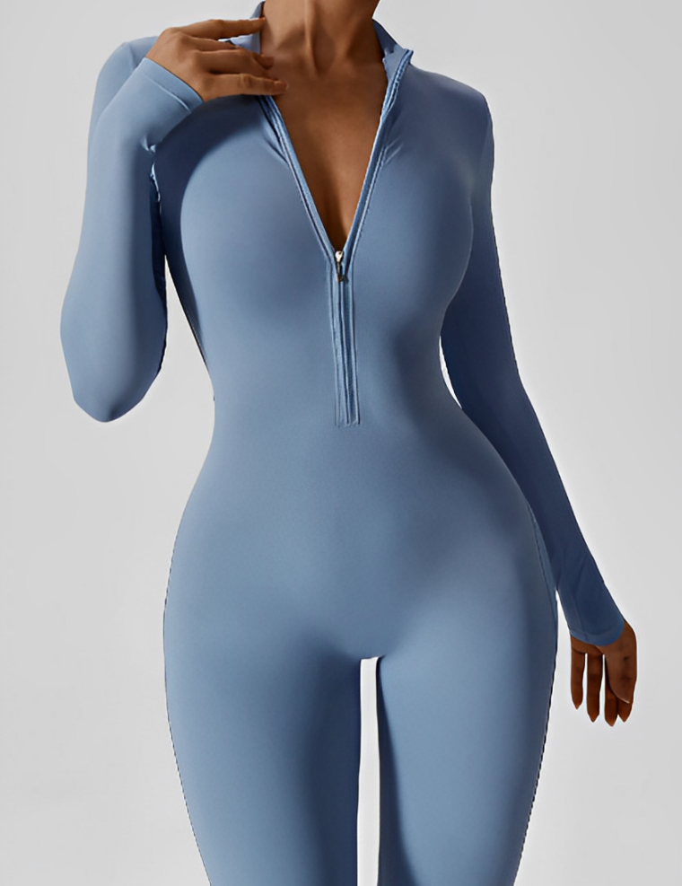 Tuta sportiva donna blu, maniche lunghe, zip frontale, design aderente. Abbigliamento fitness elegante e moderno per allenamenti e yoga.