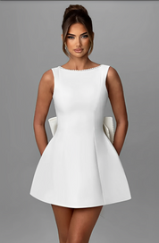 Abito bianco elegante da donna, senza maniche, con scollo rotondo e gonna svasata. Perfetto per cerimonie e occasioni speciali.