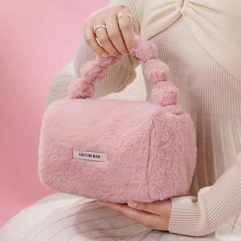 Borsa a mano rosa in pelliccia sintetica, design rettangolare, manico con pompon, moda donna, elegante accessorio invernale.