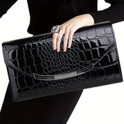 Borsa clutch nera in pelle effetto coccodrillo, elegante e lucida, con chiusura metallica. Accessorio moda donna, perfetto per eventi serali.