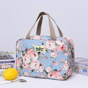 Borsa termica floreale blu con manici beige, ideale per picnic e viaggi. Design elegante con rose rosa, perfetta per conservare cibi freschi.