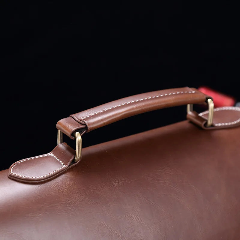 Manico di valigetta in pelle marrone con cuciture bianche, dettagli in metallo dorato, sfondo nero. Elegante accessorio business.