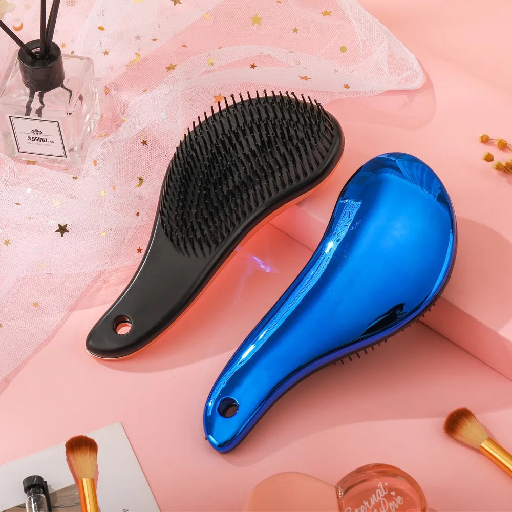 Due spazzole districanti, una nera e una blu, su sfondo rosa con accessori di bellezza. Design ergonomico, ideale per capelli lisci e ricci.