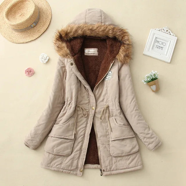 Giacca invernale beige con cappuccio foderato in pelliccia sintetica, tasche frontali e chiusura a zip. Perfetta per moda donna autunno inverno.