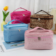 Quattro beauty case colorati in tessuto con cerniera: rosa, blu, marrone e fucsia. Ideali per cosmetici, viaggio, organizzazione trucco.
