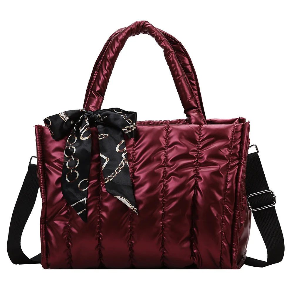 Borsa a mano trapuntata in raso rosso con manici imbottiti, tracolla regolabile e foulard decorativo nero. Elegante e versatile per ogni occasione.