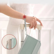 Donna con valigia e borsa a tracolla verde chiaro, evidenziato punto di pressione sul polso. Accessori da viaggio eleganti e funzionali.