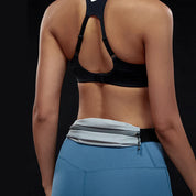Donna in abbigliamento sportivo, reggiseno nero e leggings blu, con marsupio grigio. Fitness, moda sportiva, accessori palestra.