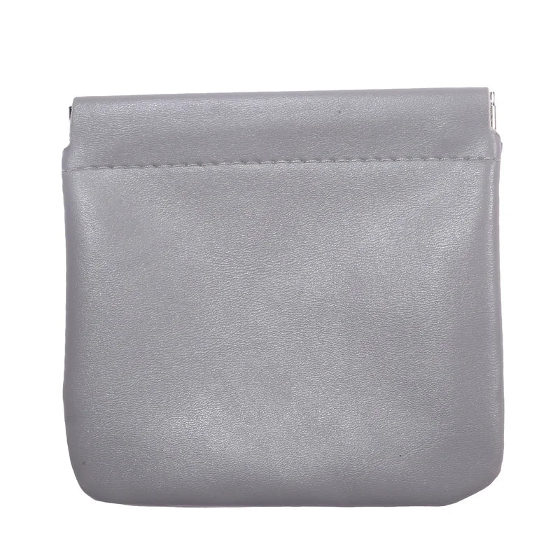 Portamonete in pelle grigia, design minimalista, chiusura a scatto, accessorio moda elegante, ideale per donna, compatto e pratico.