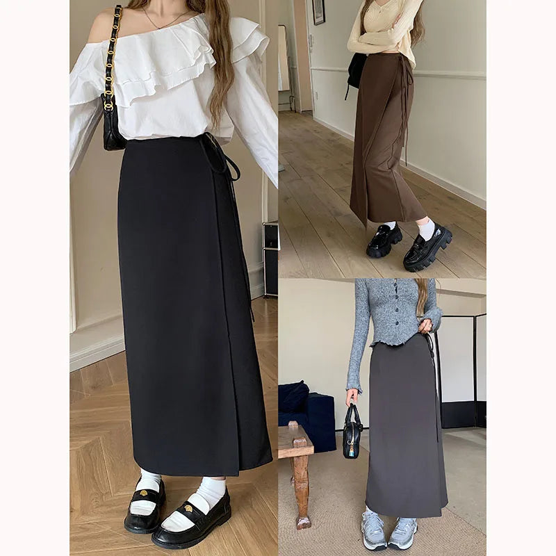 Tre donne indossano gonne lunghe in diversi stili: nera con camicia bianca, marrone con maglione beige, grigia con cardigan blu. Moda casual elegante.