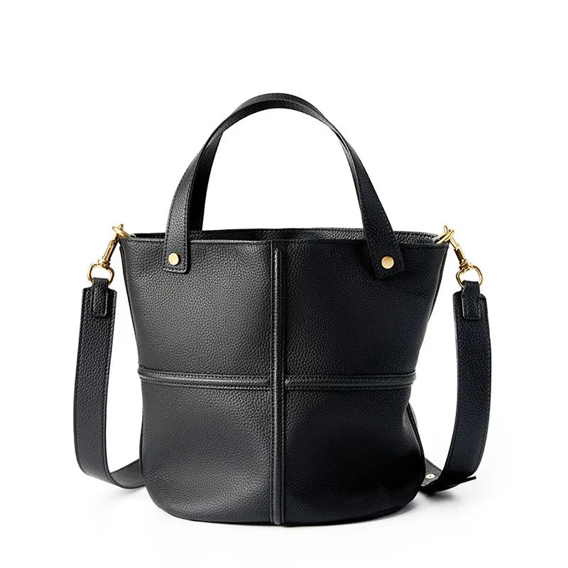 Borsa a secchiello in pelle nera con tracolla regolabile, manici corti e dettagli in metallo dorato. Design elegante e moderno per donna.